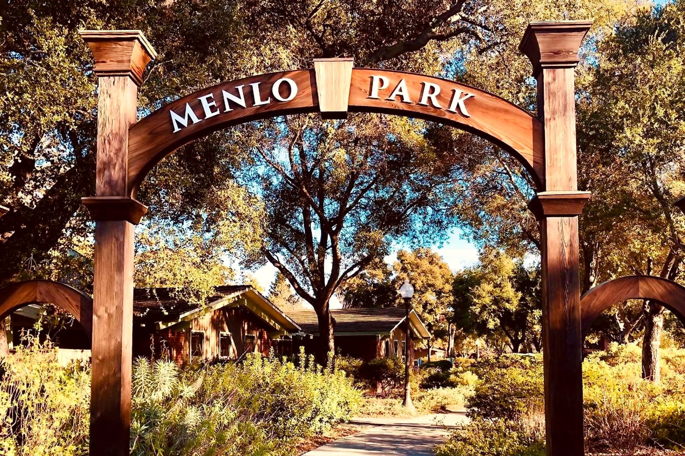 The Menlo Park arch over a path lined with oak trees